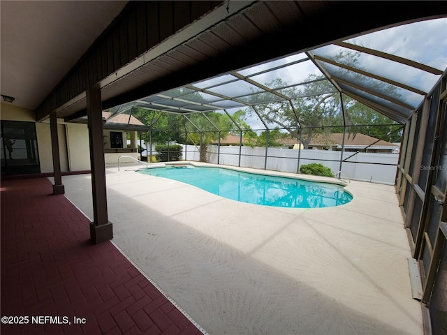 view of swimming pool with a fenced in pool, glass enclosure, a patio area, and fence