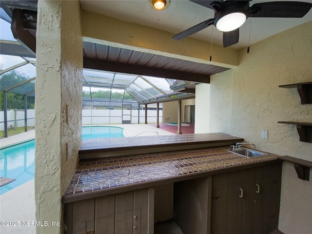 view of patio / terrace featuring ceiling fan, a sink, a fenced in pool, and a lanai