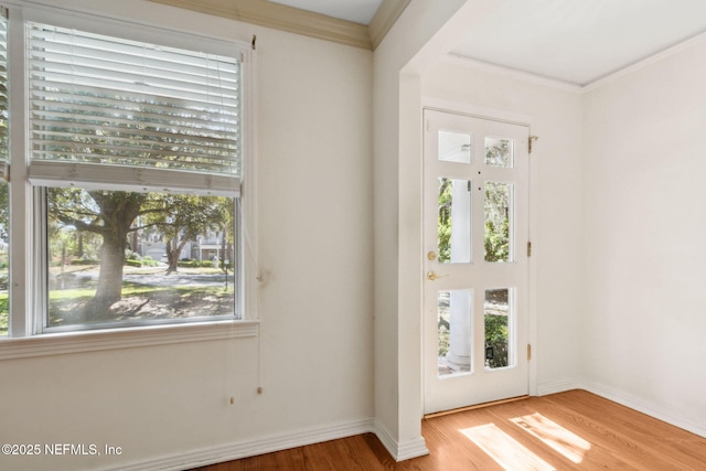 entrance foyer with a wealth of natural light, crown molding, and wood finished floors