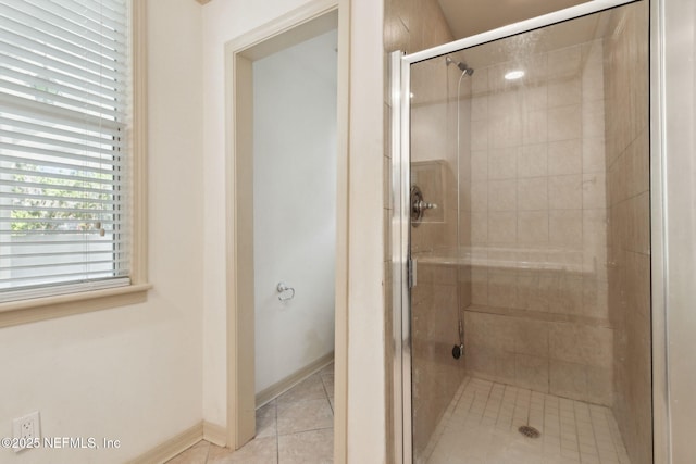 bathroom with a shower stall, baseboards, and tile patterned floors