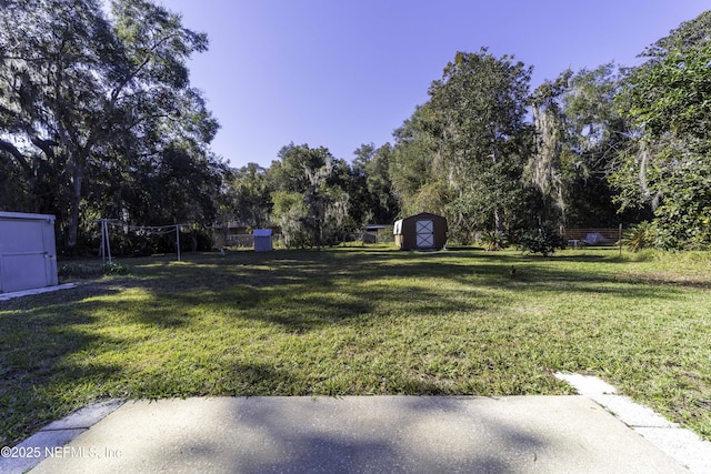 view of yard with an outbuilding, a shed, and fence