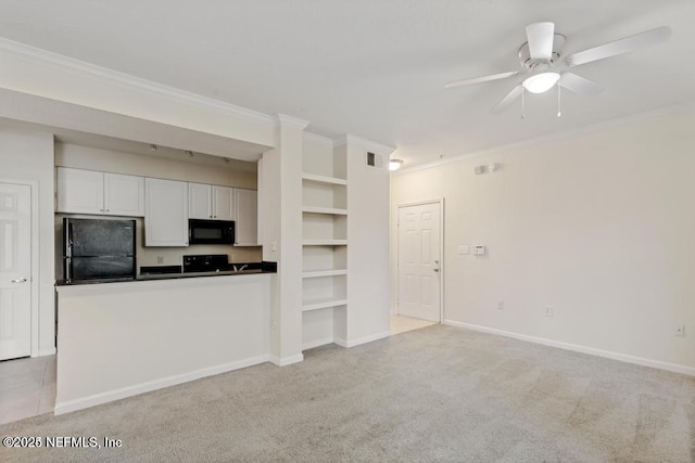 kitchen featuring crown molding, black appliances, dark countertops, and light colored carpet