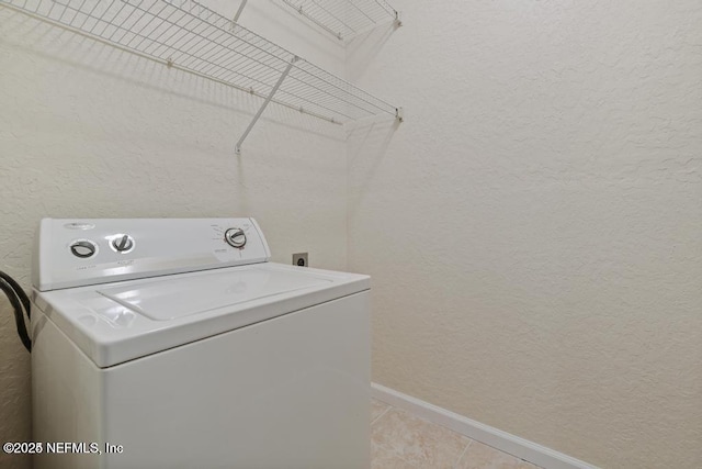 laundry area with a textured wall, light tile patterned flooring, washer / dryer, laundry area, and baseboards