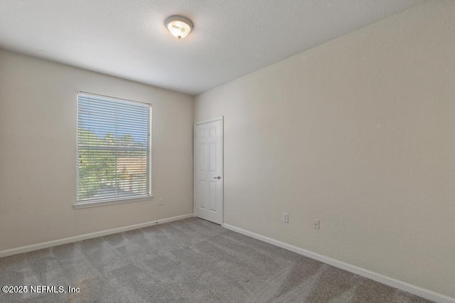 carpeted empty room with baseboards