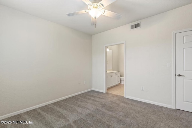 unfurnished bedroom featuring ceiling fan, connected bathroom, light colored carpet, visible vents, and baseboards