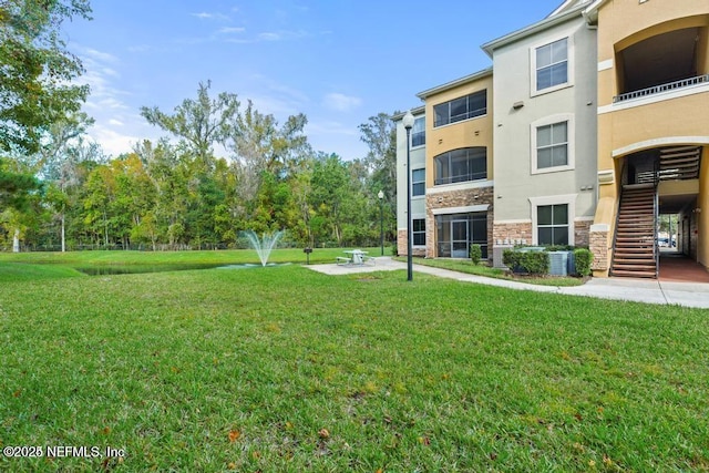 view of community with a lawn and stairway