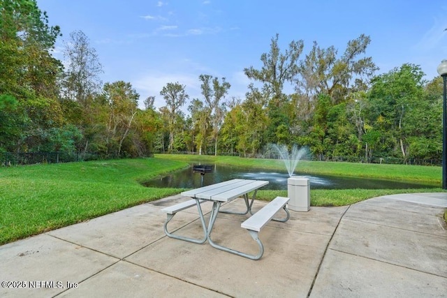 surrounding community featuring a water view and a lawn