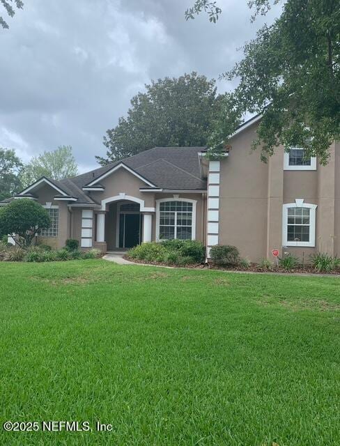 view of front facade with a front lawn and stucco siding