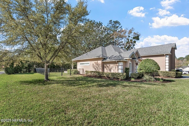 view of front of house with fence, a front lawn, and stucco siding