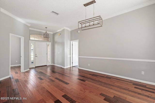 entrance foyer featuring ornamental molding, wood-type flooring, visible vents, and baseboards