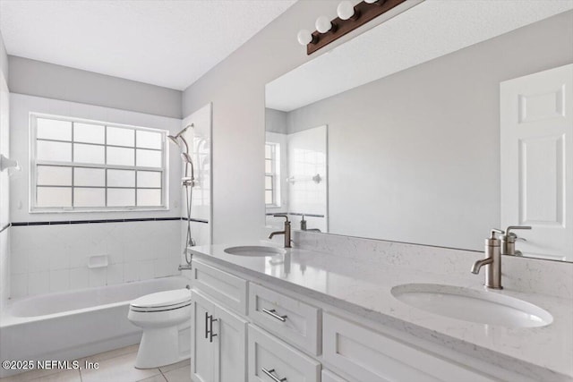 bathroom featuring double vanity, a sink, toilet, and tile patterned floors