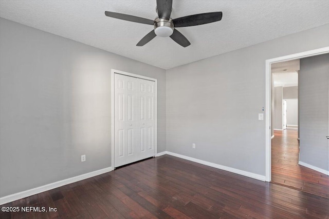 unfurnished bedroom with a closet, baseboards, a textured ceiling, and hardwood / wood-style floors