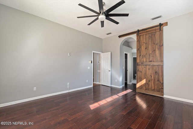 spare room featuring a ceiling fan, baseboards, visible vents, and wood finished floors