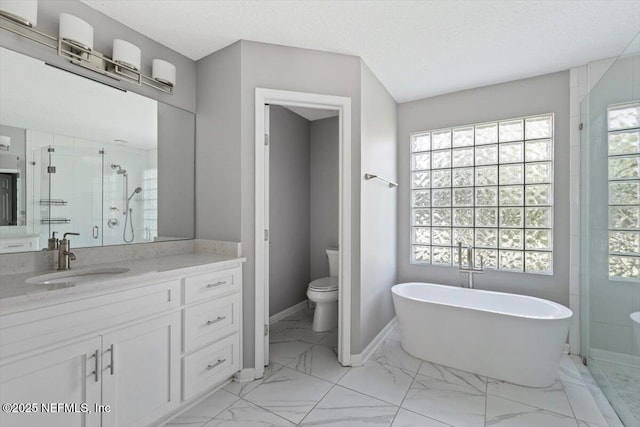 full bathroom featuring a stall shower, baseboards, marble finish floor, vanity, and a freestanding tub