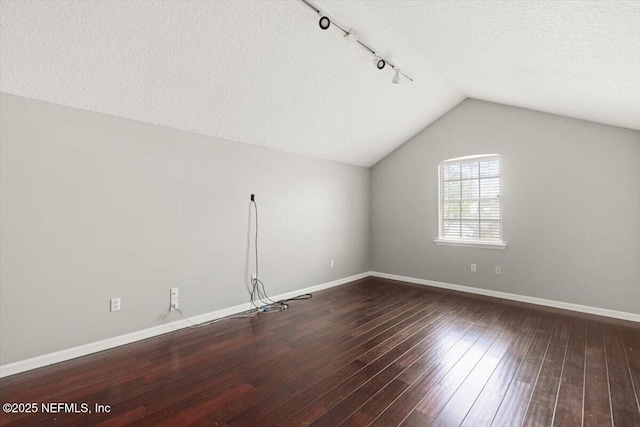 bonus room featuring vaulted ceiling, a textured ceiling, wood finished floors, and baseboards