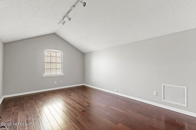 bonus room featuring lofted ceiling, wood-type flooring, visible vents, and a textured ceiling