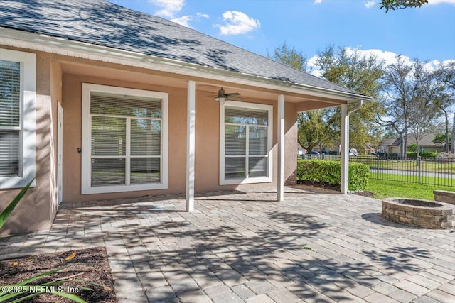 view of patio / terrace with a fire pit, ceiling fan, and fence