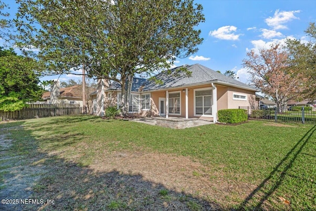 back of property with a lawn, a fenced backyard, and stucco siding