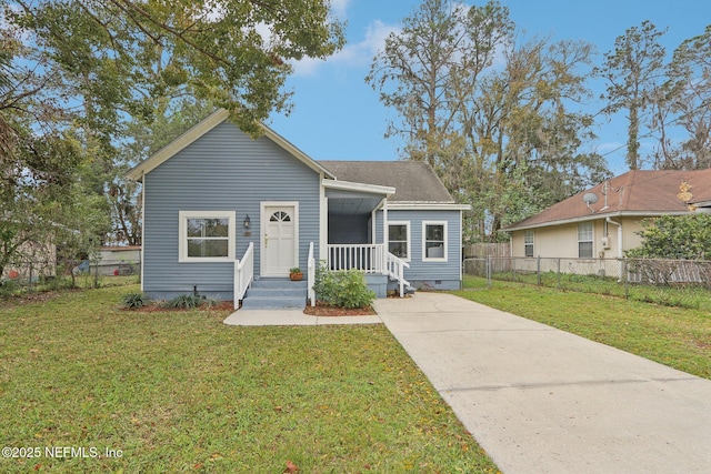 bungalow-style house with a shingled roof, crawl space, fence, and a front lawn