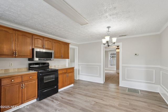 kitchen with black range with electric cooktop, stainless steel microwave, brown cabinetry, and visible vents