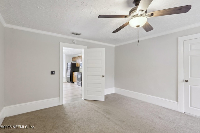 empty room with baseboards, visible vents, ornamental molding, carpet, and a textured ceiling