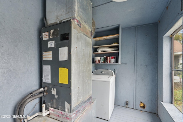 washroom with heating unit, laundry area, washer / clothes dryer, and wood finished floors