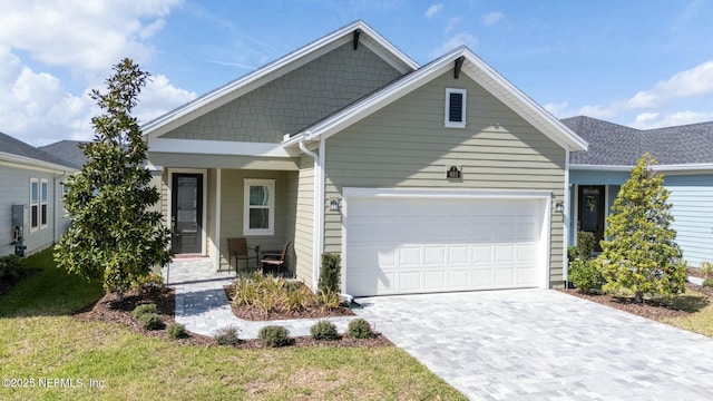 view of front of house with a garage, covered porch, and decorative driveway