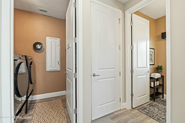 washroom featuring laundry area, baseboards, visible vents, washer and clothes dryer, and wood tiled floor