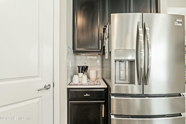 kitchen with stainless steel fridge, tasteful backsplash, and light countertops