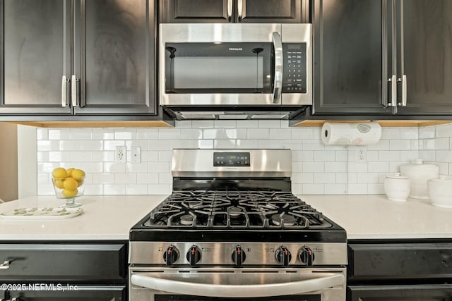 kitchen with appliances with stainless steel finishes, light countertops, and tasteful backsplash