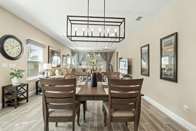 dining area with wood finish floors, visible vents, and baseboards