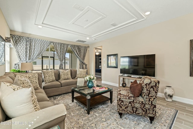 living room featuring baseboards, visible vents, and wood finish floors