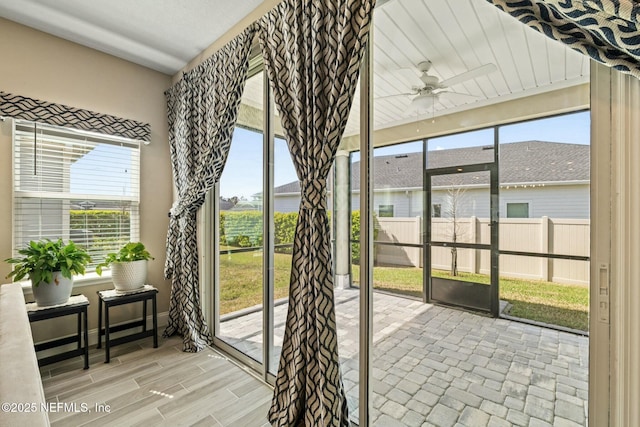 sunroom / solarium featuring a ceiling fan