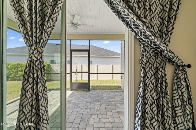 doorway to outside with brick floor and ceiling fan