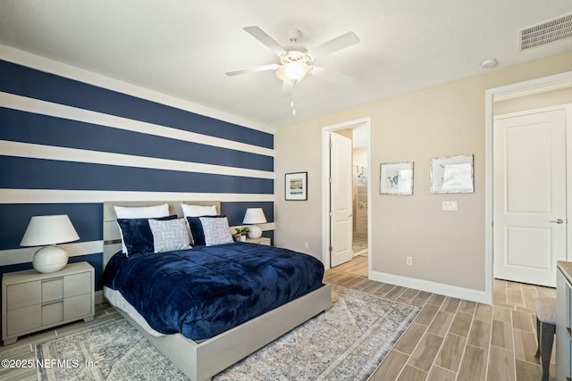 bedroom featuring a ceiling fan, wood tiled floor, visible vents, and baseboards