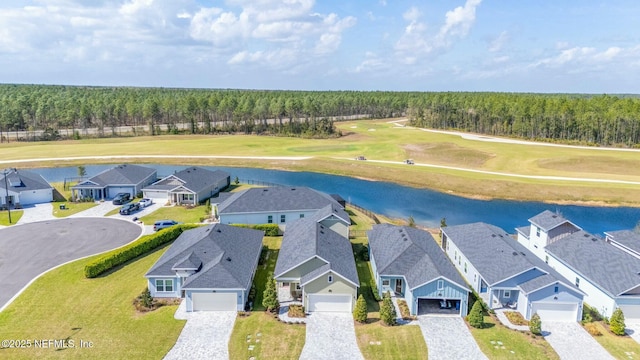 drone / aerial view featuring a residential view, a water view, and a forest view