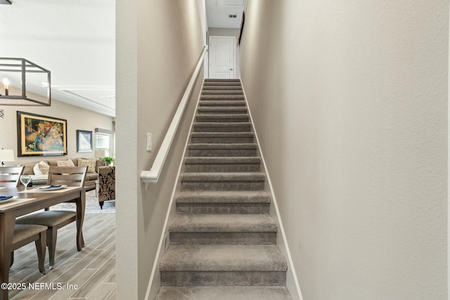 staircase featuring wood finished floors and baseboards