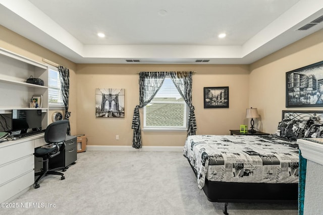 bedroom with carpet floors, visible vents, and a raised ceiling