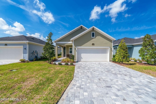 view of front of property with a front lawn, decorative driveway, and an attached garage