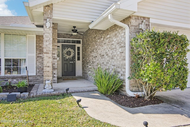 doorway to property featuring brick siding and roof with shingles