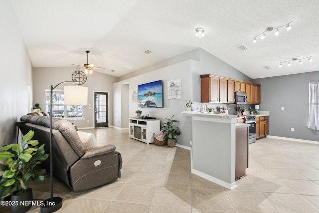 living room featuring light tile patterned flooring, baseboards, and lofted ceiling