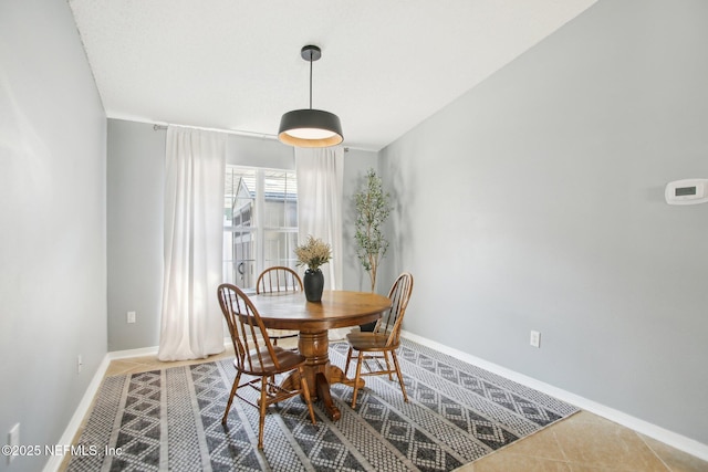 dining space with baseboards and tile patterned flooring