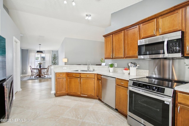 kitchen featuring brown cabinets, stainless steel appliances, and a sink