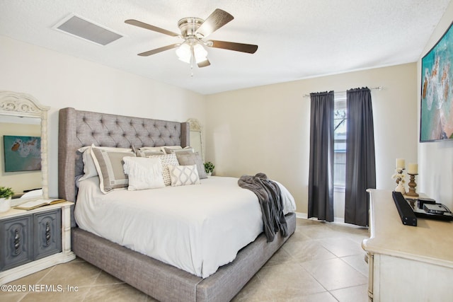 bedroom featuring light tile patterned floors, visible vents, a textured ceiling, and a ceiling fan