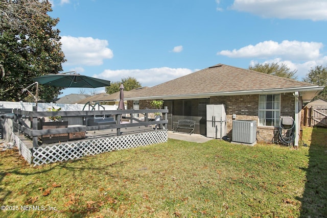 view of yard featuring a deck, central AC unit, and fence