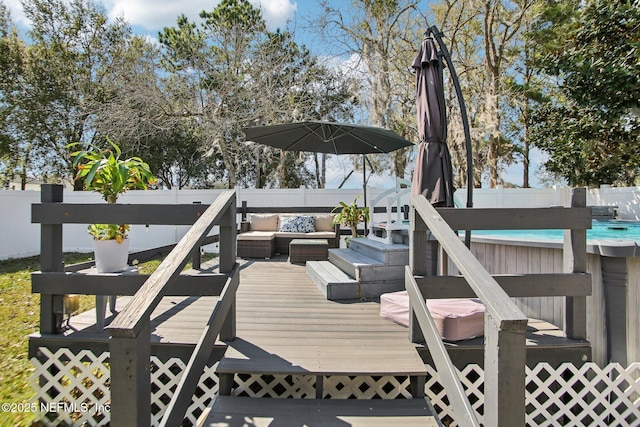 wooden terrace with outdoor lounge area, a pool, and fence