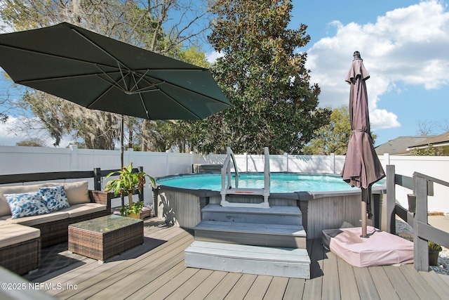 deck featuring a fenced in pool, an outdoor hangout area, and a fenced backyard