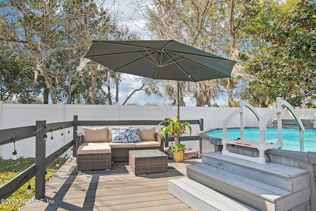 deck featuring outdoor lounge area, a fenced backyard, and a fenced in pool