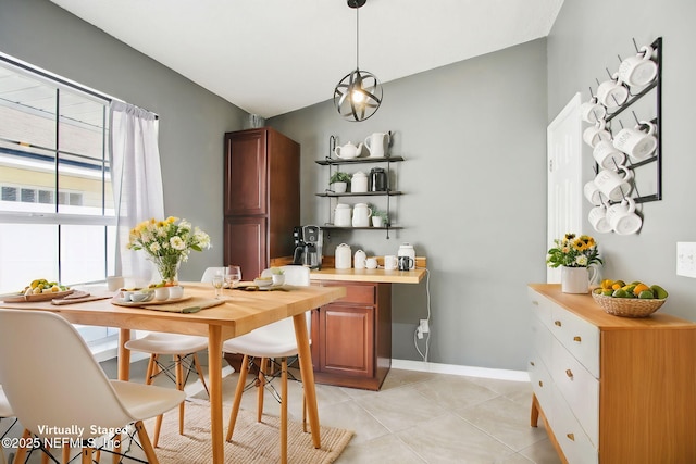 dining area featuring light tile patterned floors and baseboards