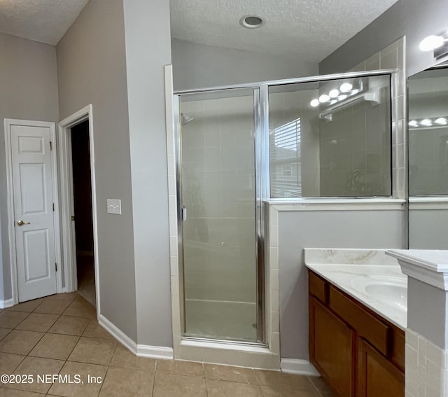 bathroom featuring lofted ceiling, a stall shower, a textured ceiling, vanity, and tile patterned flooring